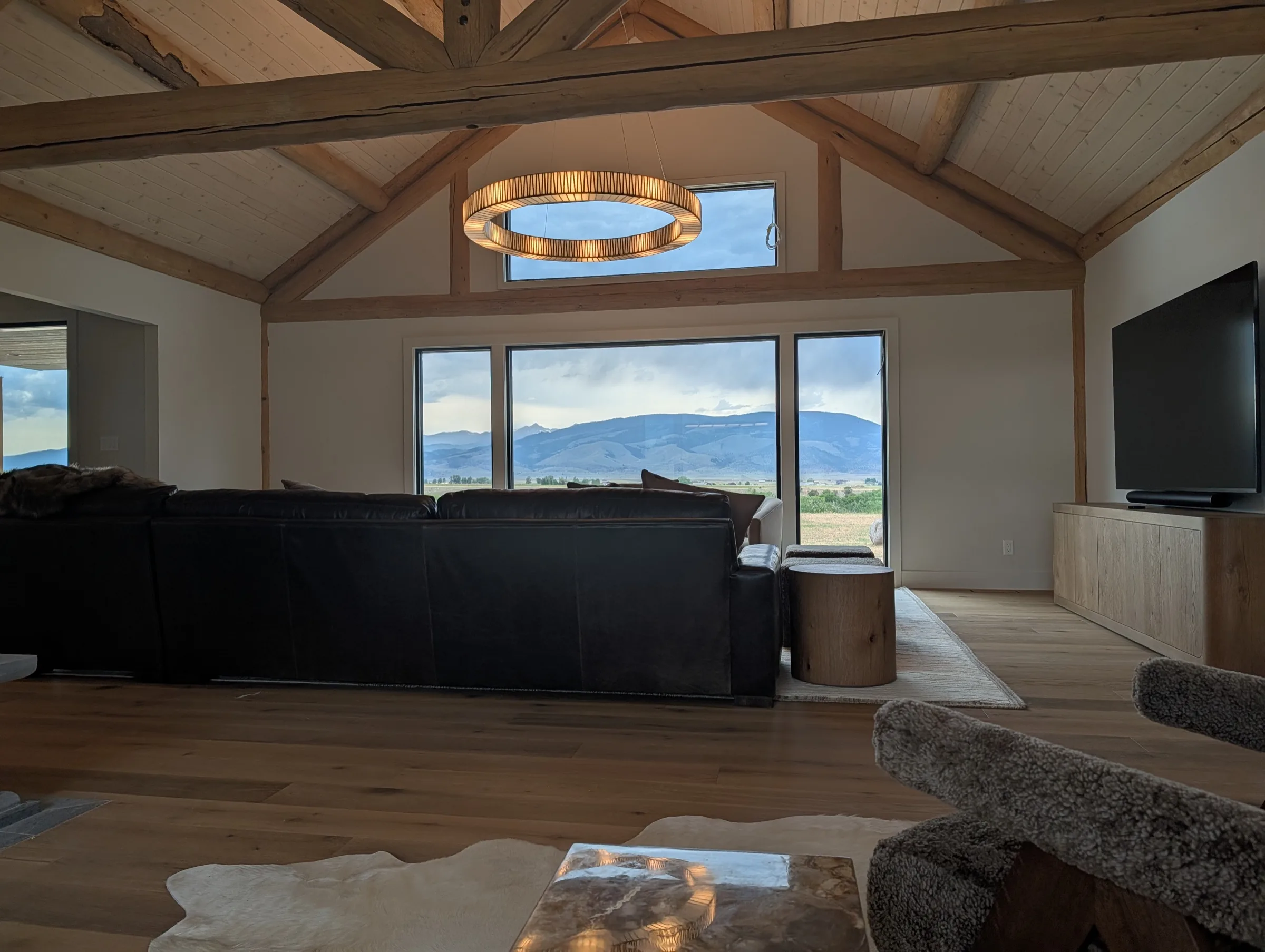 Exposed timber beams frame the living room and its view of the mountains.